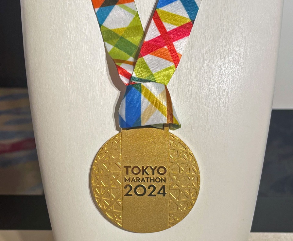 東京マラソン2024の金メダル。手にできたのはエリート男女、車いすエリート男女の各勝者4人のみ！　裏面には、東京マラソン2024という大会名が点字で刻まれ、さらに今大会のキャッチコピー「TOKYO, My Favorite Place...」という文字と開催日2024.3.3も記されている。