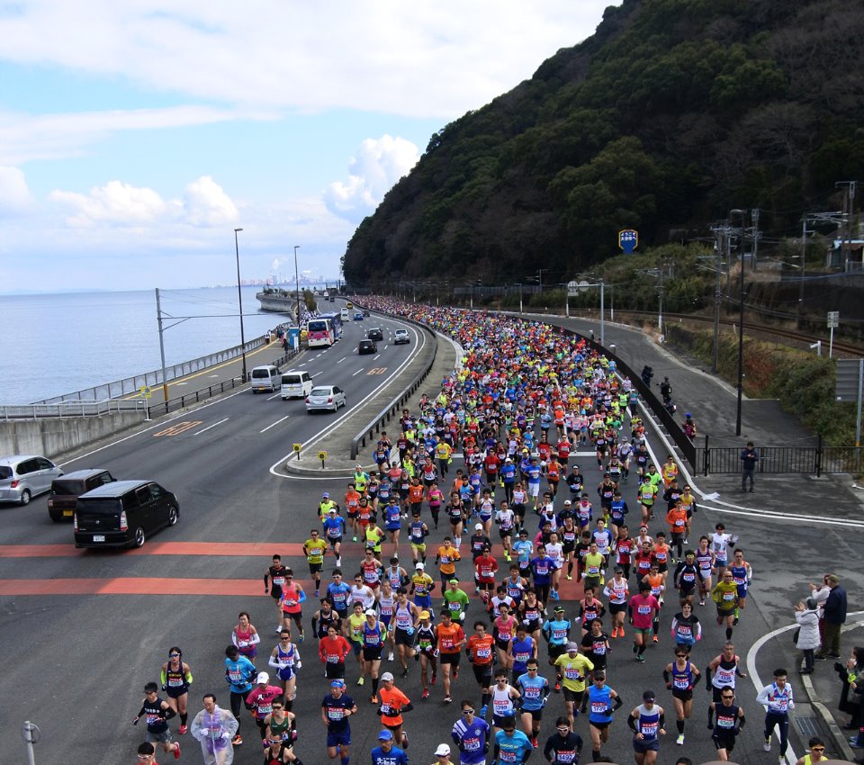 別府大分毎日マラソンのスタートから2km手前を疾走するランナーたち。ブラインドランナー19人（男子13人、女子6人）を含む、過去最多となる3402人が出走した。（2016年2月7日／大分県別府市＝撮影：星野恭子）